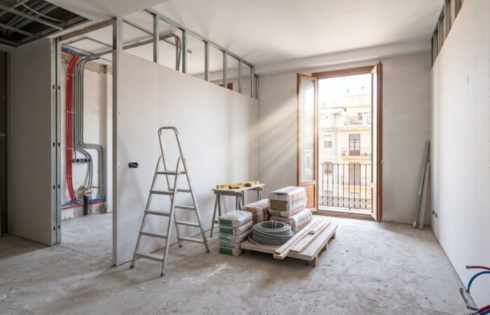 Vivienda en Valencia en fase de obra, con tabiques nuevos de pladur, instalaciones vistas y luz entrando por el balcón